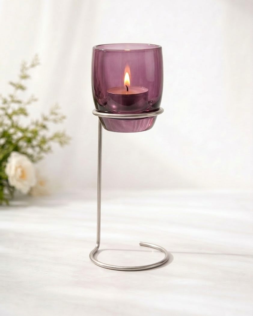Purple candle holder with a lit candle on a white surface, with a blurred background