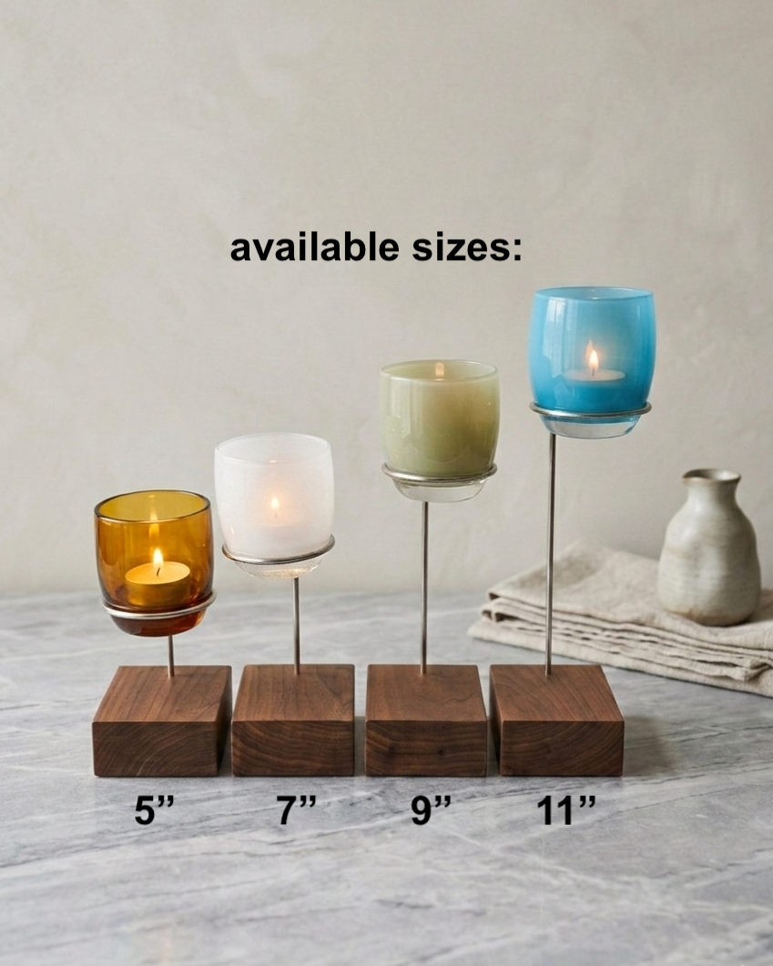 Set of candle holders with varying heights on a marble surface.