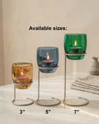 Three glass candle holders with different sizes on a neutral background